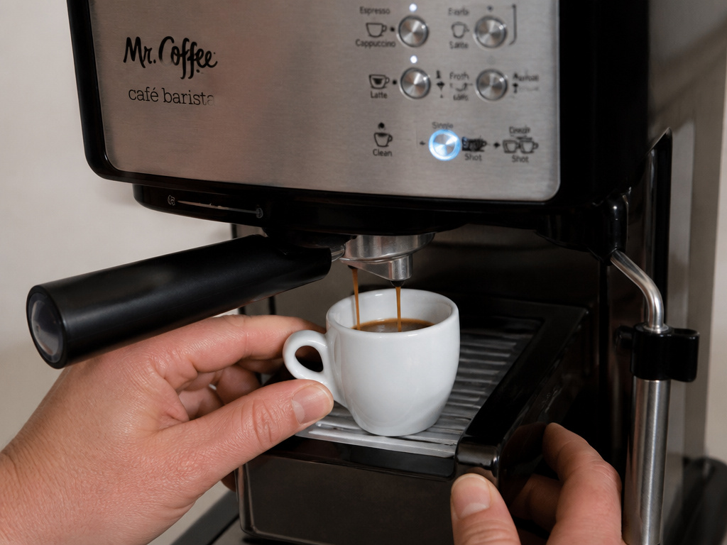 Mr. Coffee Cafe Barista brewing an espresso shot into a small cup.