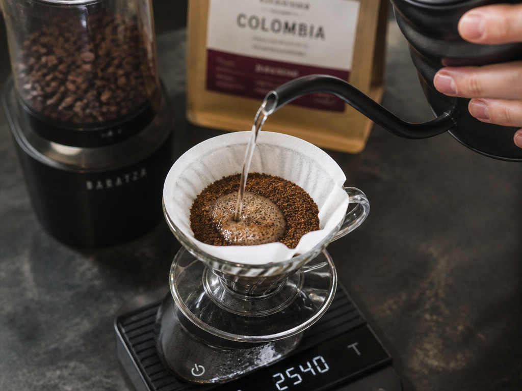 Essential coffee tools: gooseneck kettle, burr grinder, and scale for perfect water ratio.