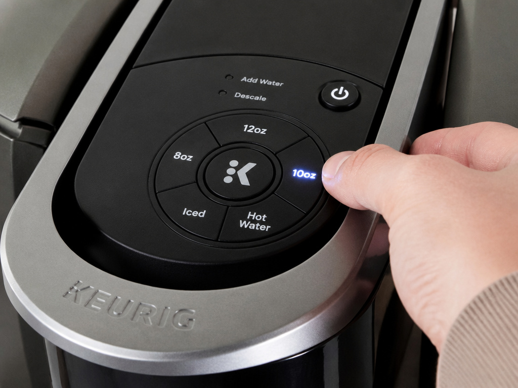 Close-up of activating the high altitude setting on a Keurig K-Elite coffee maker.
