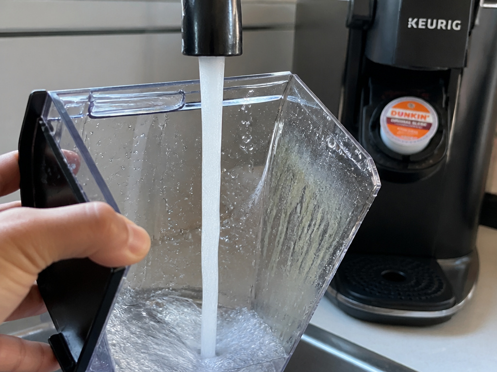 Rinsing Keurig water reservoir to prevent biofilm and musty coffee taste.