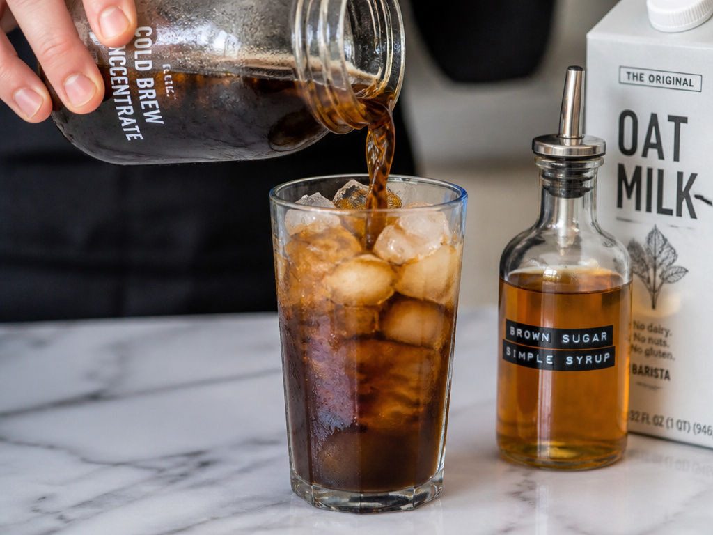 Pouring homemade cold brew concentrate over ice for serving and customizing