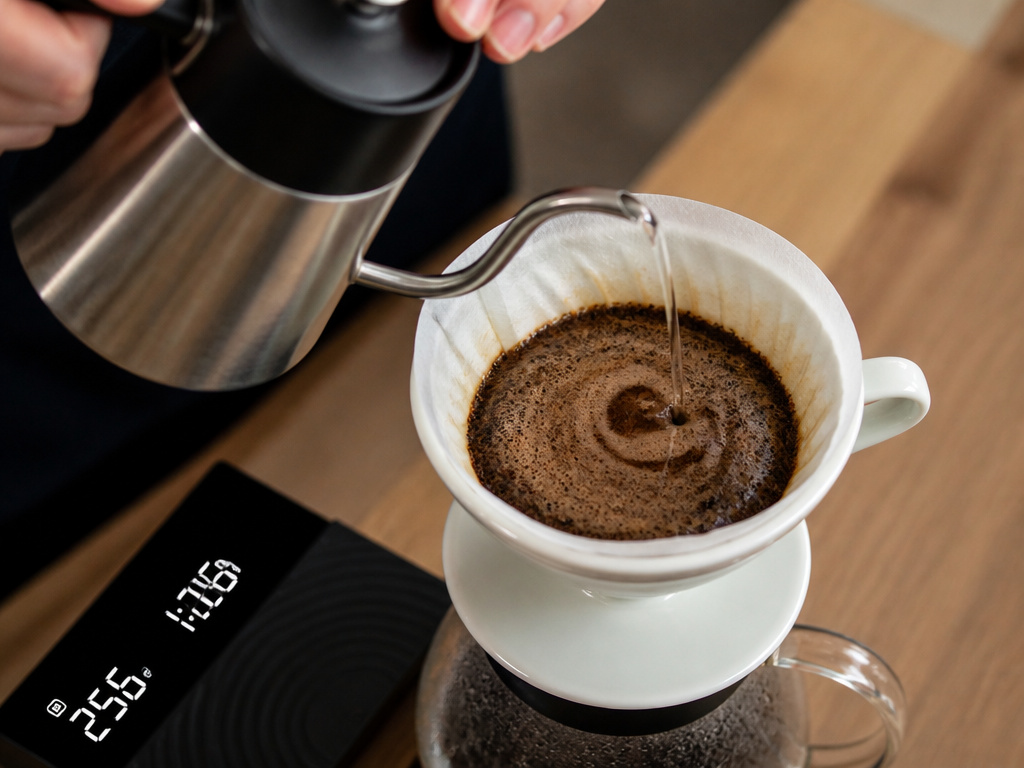 Pour-over coffee brewing method, hand pouring hot water over grounds in a V60 dripper.
