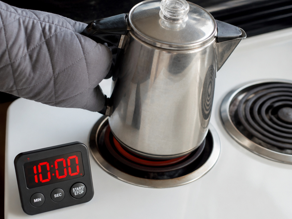 Moving a percolator off heat at the ten minute mark to prevent bitter coffee.